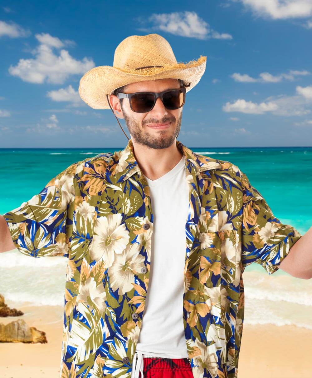Model wearing a tropical print shirt on the beach